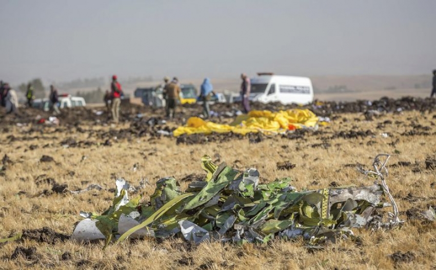 Partes de los restos del vuelo 302 de Ethiopian Airlines, con trabajadores de rescate en el lugar del accidente en las afueras de Addis Abeba.