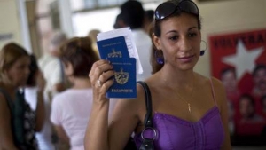 Una mujer muestra su pasaporte y el de su hijo al dejar una oficina de inmigración en La Habana, Cuba. 