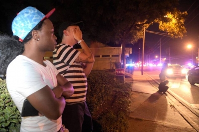 Jermaine Towns, izquierda, y Brandon Shuford esperan en la calle tras un tiroteo m&uacute;ltiple en un club nocturno en Orlando