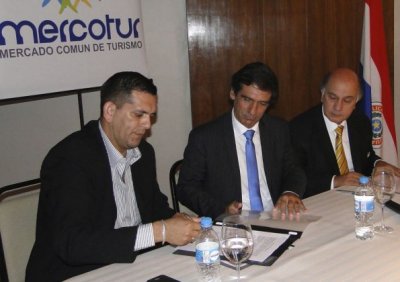 Nery Jara, presidente de la Junta Municipal de Ciudad del Este, firma el convenio. A su lado, el alcalde de Punta del Este, Martín Laventure, y Derlis Esteche, de Fundapueblos. 